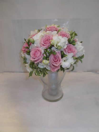 Svatební kytice z růžových růží doplněných eustomou.